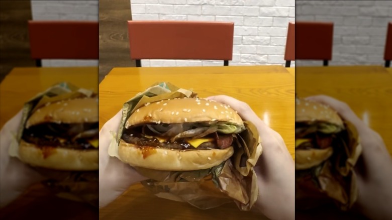 Hands holding Burger King K-Spicy XL Beef Burger