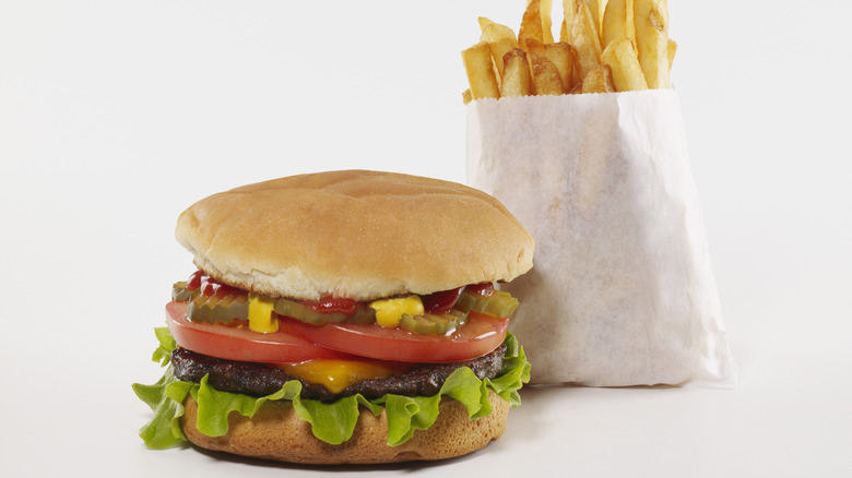 Fast food cheeseburger with fries on white background