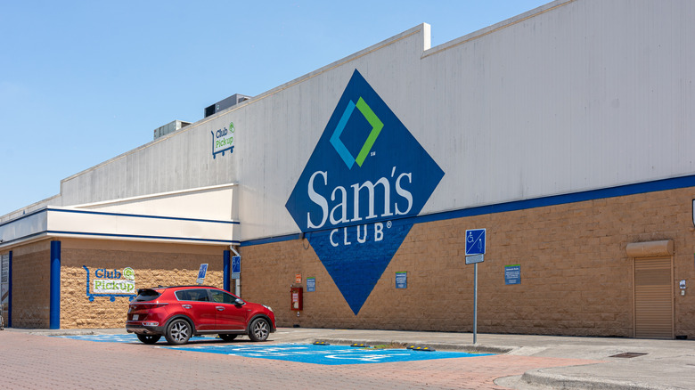 Side of Sam's Club building with red car in front