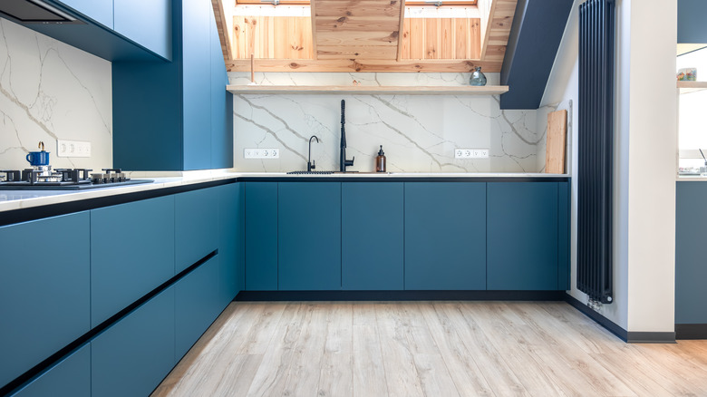 Blue kitchen with light matte wood plank flooring