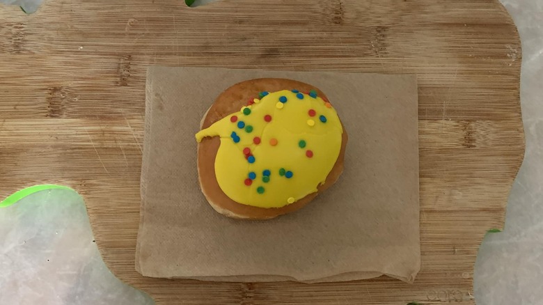 Krispy Kreme cake batter donut on paper napkin on wooden board