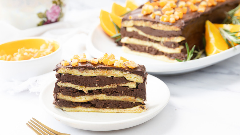 Slice of 7-layer chocolate orange passover cake with cake in background