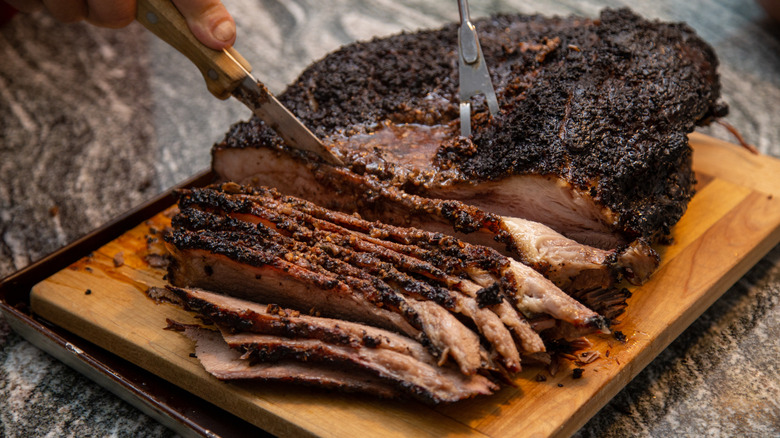 Person slicing smoked brisket