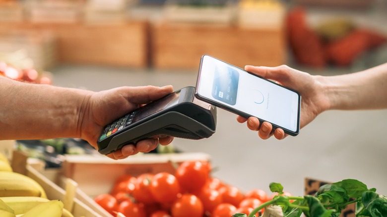 Hand paying for groceries with phone app