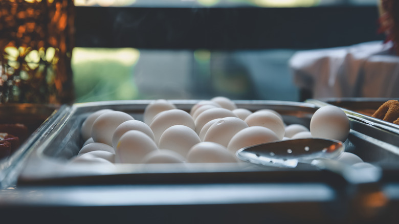 hard boiled eggs in metal container with serving spoon