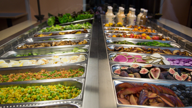 metal tins of salad ingredients on salad bar