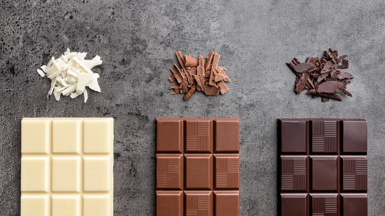 Three chocolate bars in a row: white chocolate, milk chocolate, and dark chocolate