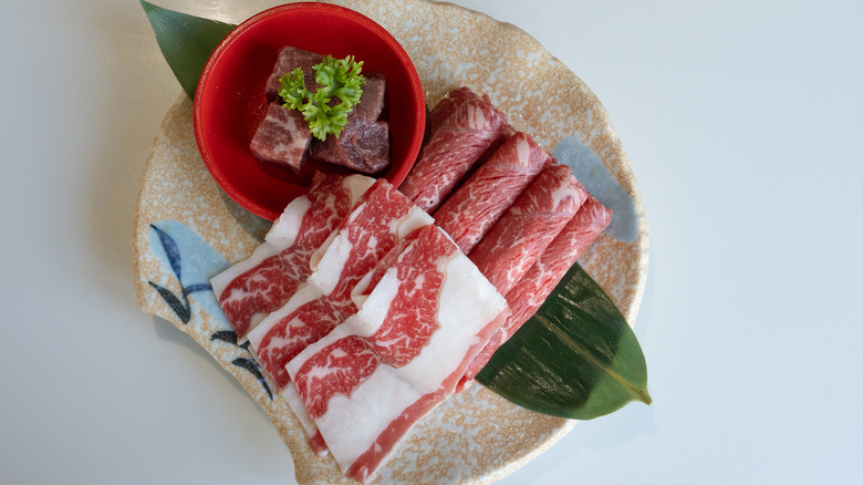 Uncooked slices of wagyu A5 beef with high marbled texture.