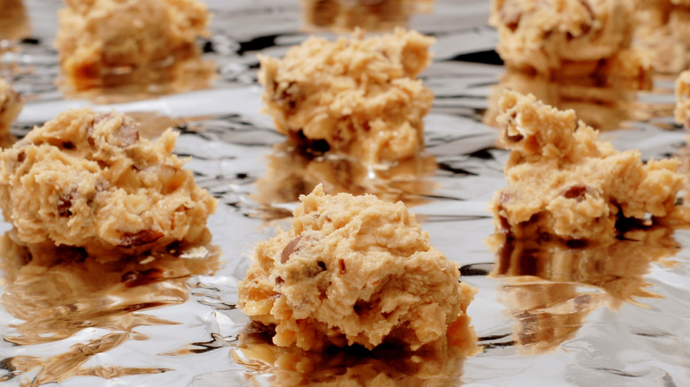 balls of raw cookie dough on tin foil