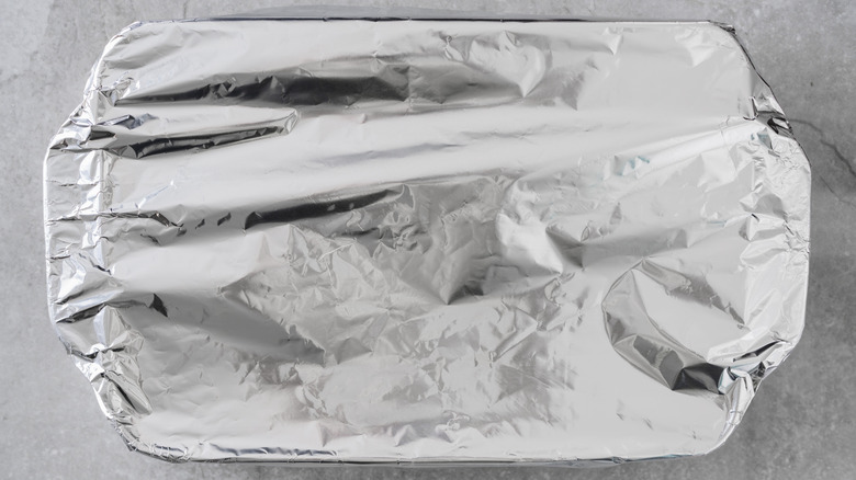 casserole dish covered in tin foil on marble counter