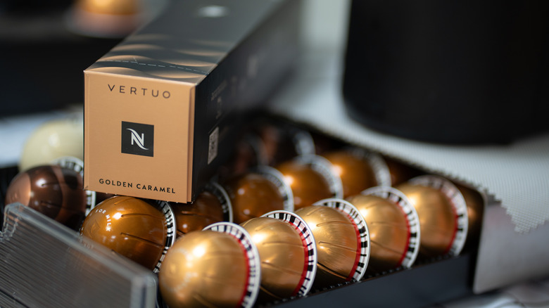 A tray full of Vertuo Nespresso capsules, with a sleeve next to them