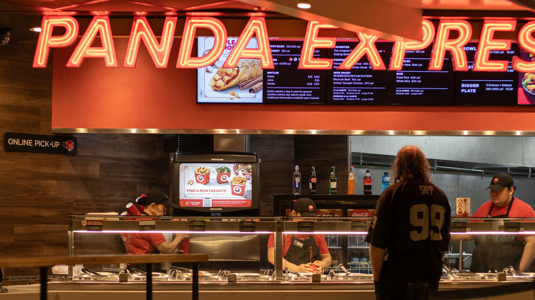 Inside of a Panda Express restaurant with someone ordering food