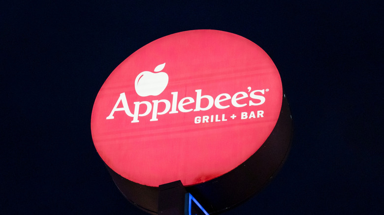 Round red Applebee's sign against dark sky