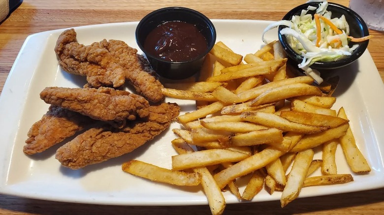 Applebee's chicken tenders and fries with ketchup and slaw on white plate