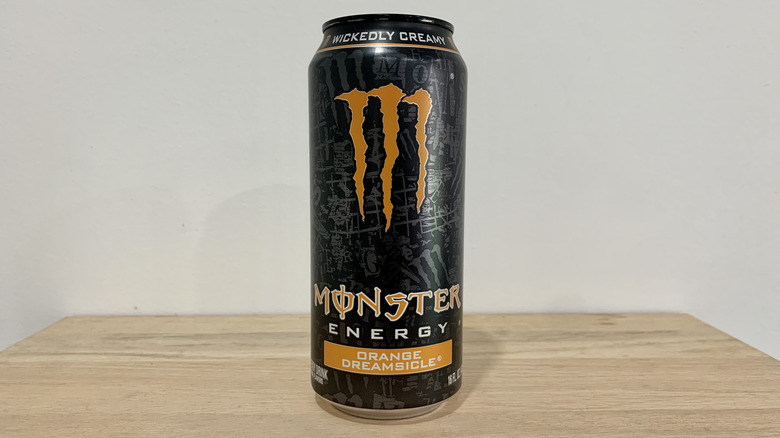 can of Monster Orange Dreamsicle on wood table with white background