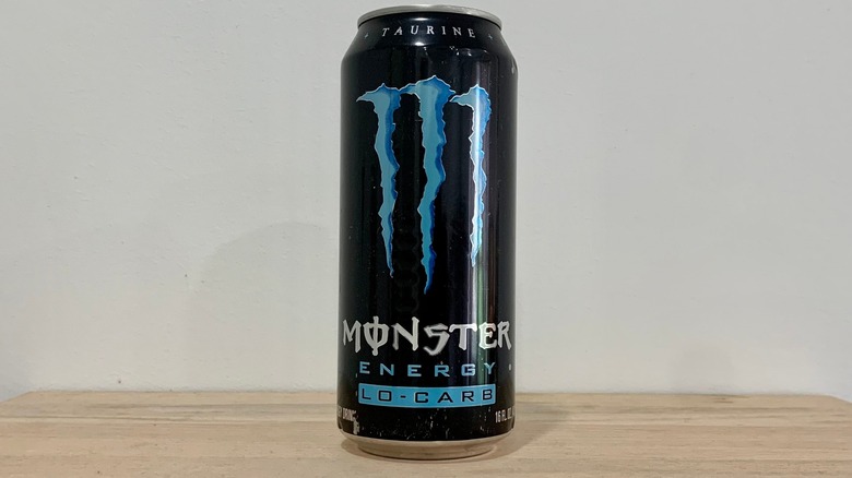 can of Monster Lo-Carb on wood table with white background