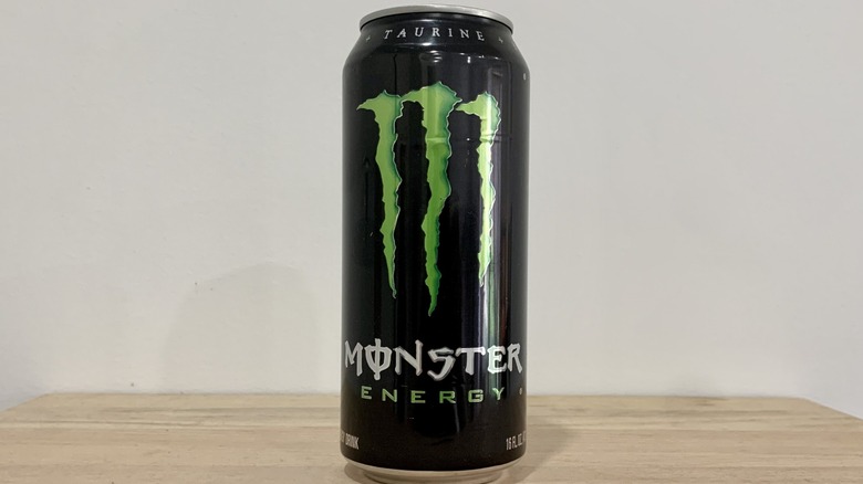can of Monster Original on wood table with white background
