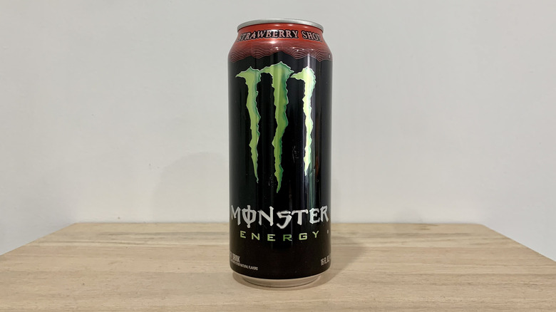 can of Monster Strawberry Shot on wood table with white background
