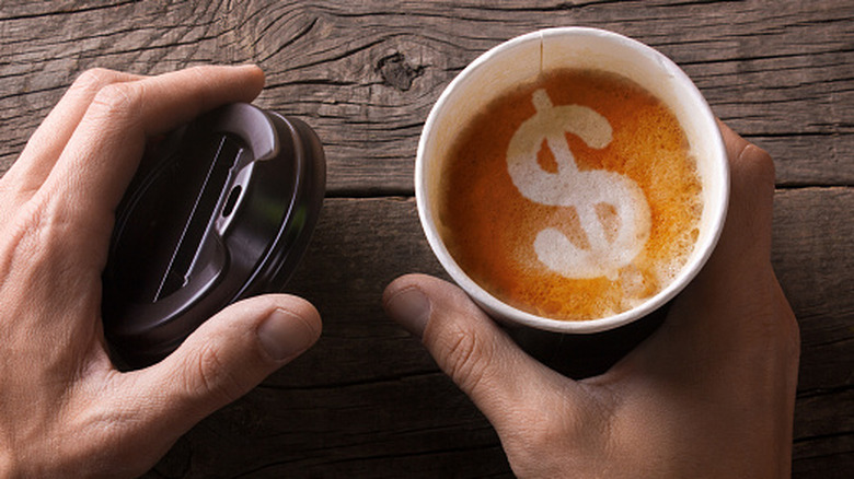 Open coffee cup with dollar sign in the foam