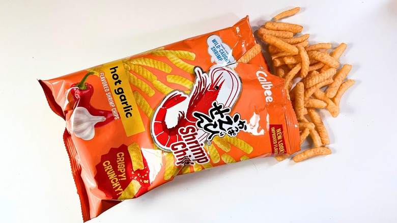 Shrimp chips spilling out of bag of Calbee Hot Garlic Shrimp Chips onto white table
