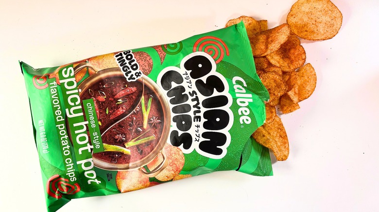 Chips spilling out of bag of Calbee Spicy Hot Pot Potato Chips onto white table