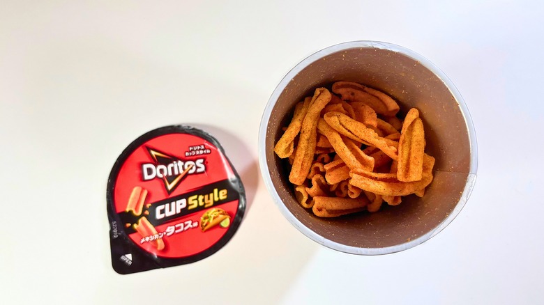 Open canister of Doritos taco cup-style chips on white table