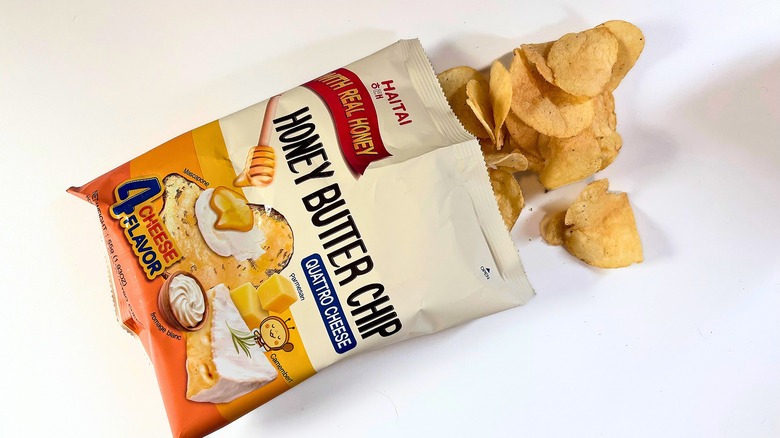 Chips spilling out of bag of Haitai Honey Butter Chips onto white table