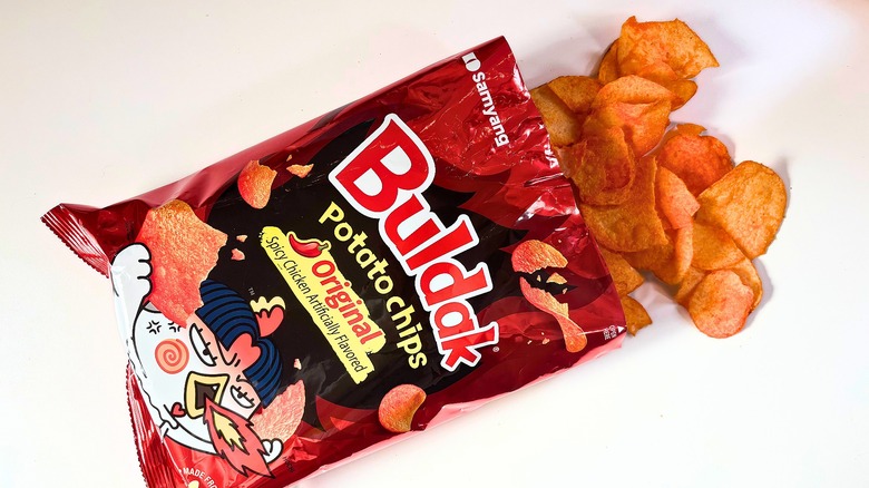 Chips spilling out of bag of Buldak Spicy Chicken Potato Chips onto white table