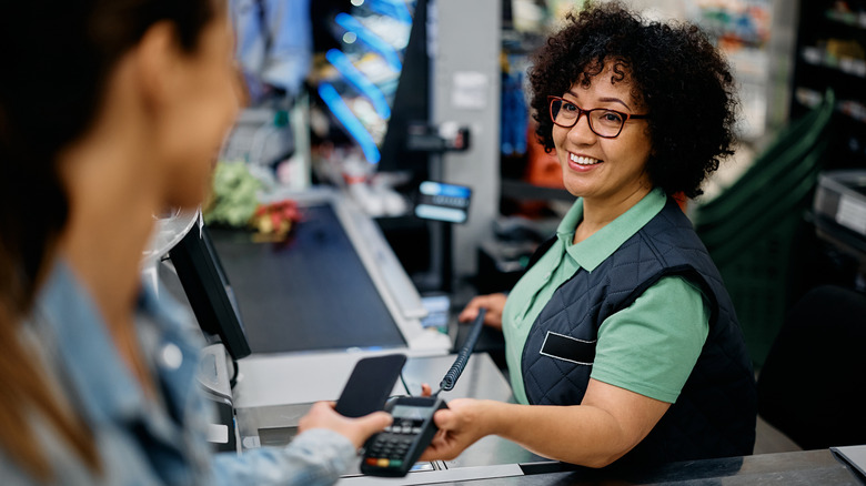 Cashier assisting customer at grocery store