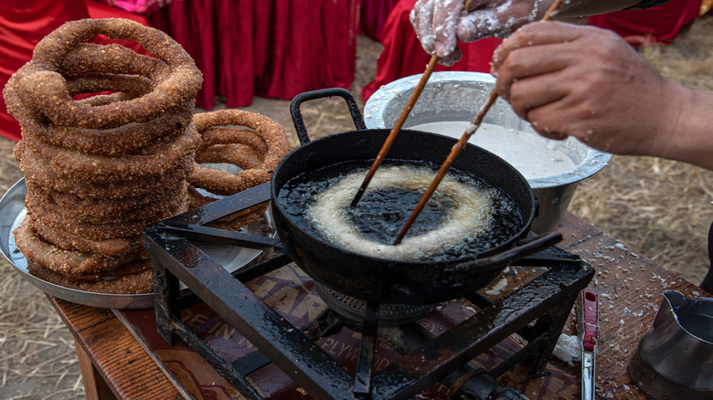 Deep-frying sel roti (traditional Nepali ring-shaped bread)