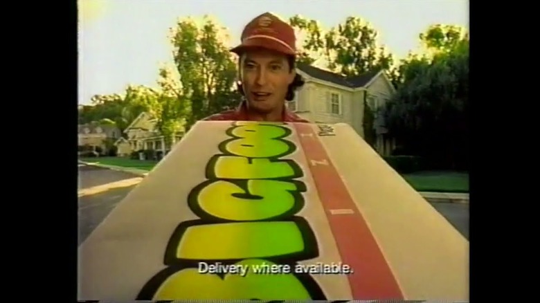 screenshot of Pizza Hut Bigfoot commercial with delivery man holding giant pizza box