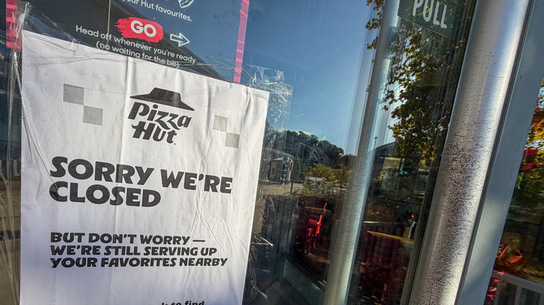 Close up of "sorry we're closed" on pizza hut door