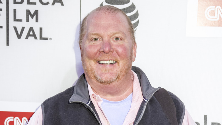 Mario Batali smiles for the cameras at a red carpet event.