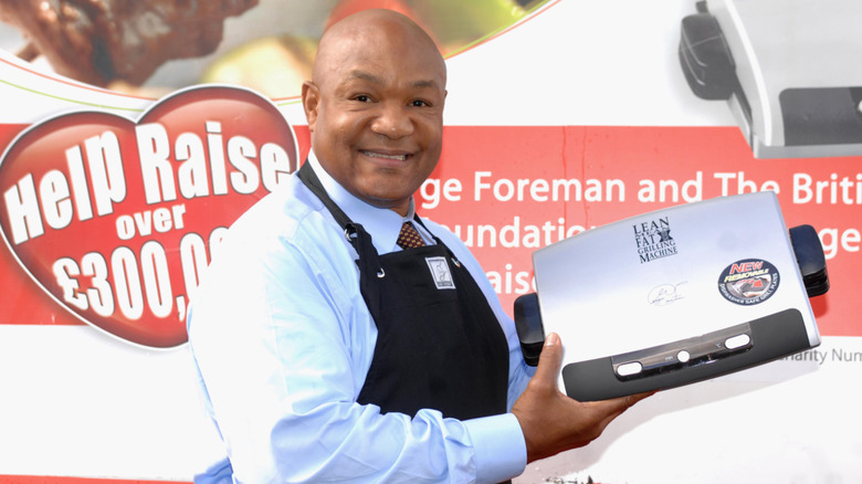 George Foreman holding his grill toward the camera
