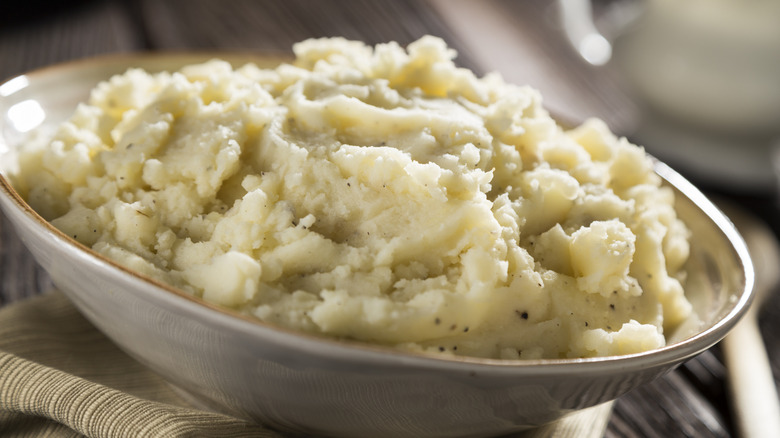A bowl of mashed potatoes on rustic table