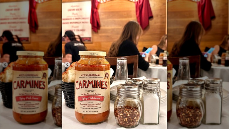 Jar of Spicy Pink Sauce alongside bread basket, salt, and pepper at Carmine's restaurant