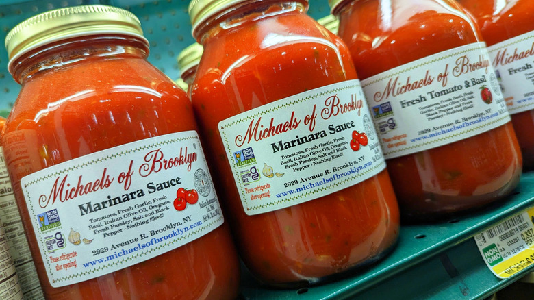 Several glass jars of Michaels of Brooklyn pasta sauces on grocery store shelf