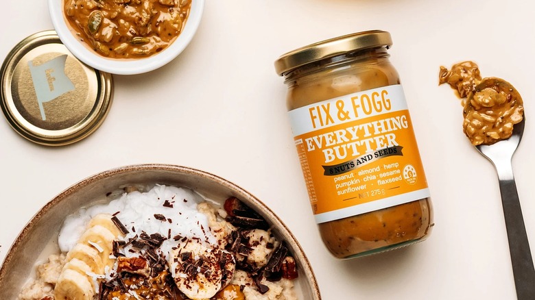 Overhead shot of Everything Butter jar alongside nut butter in spoon, bowl, and oatmeal