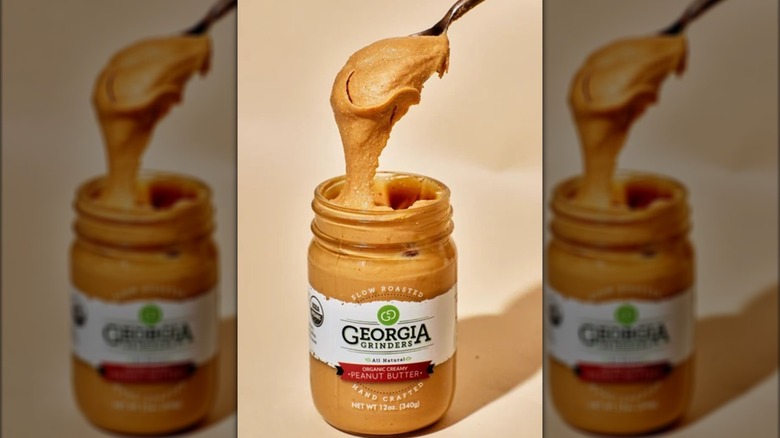 Spoon scooping creamy peanut butter out of Georgia Grinders jar