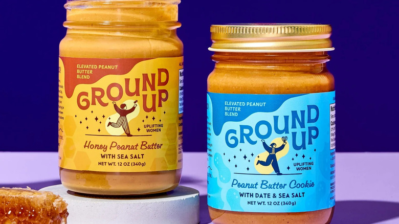 Two jars of Ground Up peanut butter with honeycomb in foreground