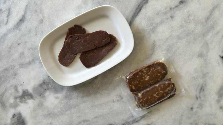Cooked Unreal Deli slices next to a vacuum-sealed pack