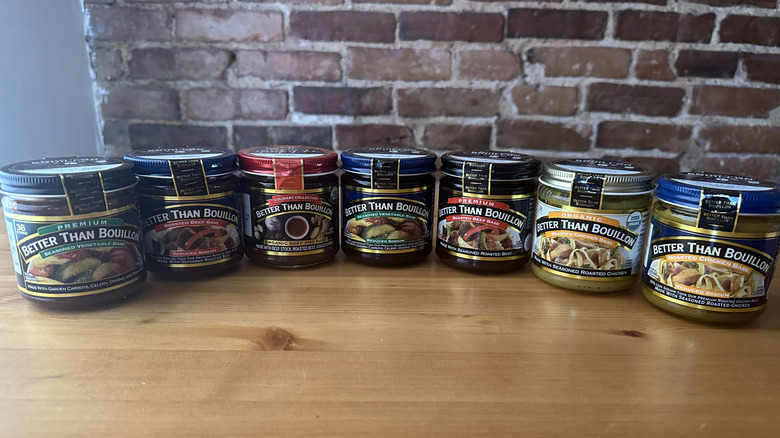 Seven jars of Better Than Bouillon arranged on wooden table