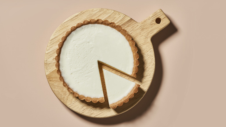 cheesecake with slice cut on wooden board