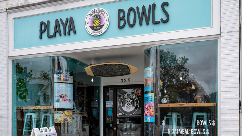 Playa Bowls entry with window seating, surfboard decor, and menu images visible