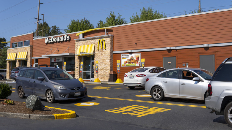 McDonald's restaurant with cars lining up at drive thru on sunny day