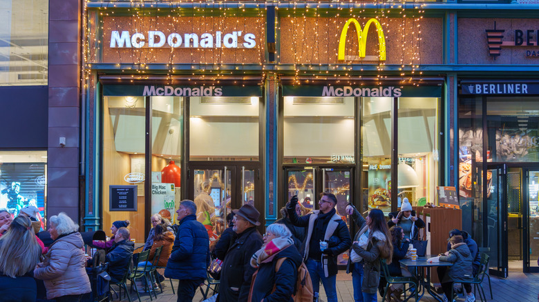 People gather outside a McDonald's restaurant decorated with festive string lights