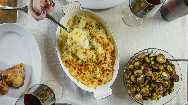 Ocean Prime jalapeño au gratin potatoes on table with various other dishes