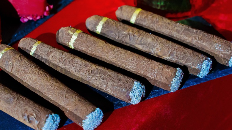 chocolate cigars on plate with a red background