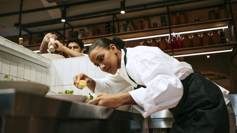 Line cook garnishing a plat in a fine dining establishment