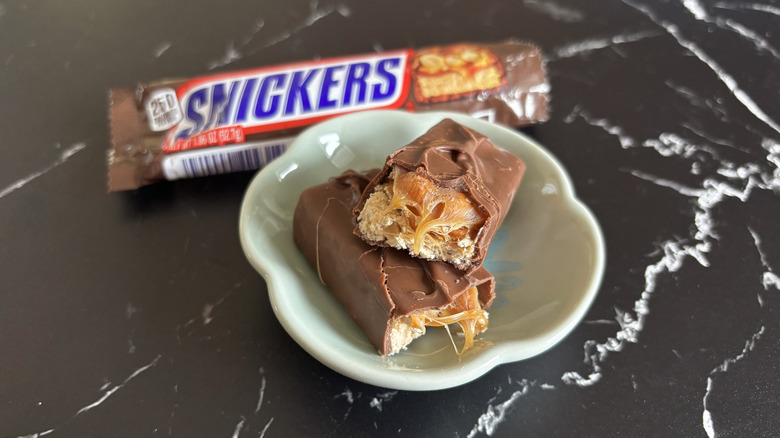 Snickers candy bar with wrapper in background